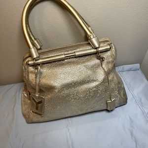Yves Saint Laurent gold zippered tote bag.